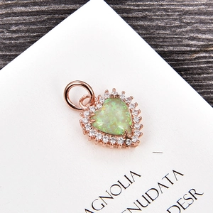Detalle de colgante de corazón en oro rosa con ópalo verde claro y circonitas