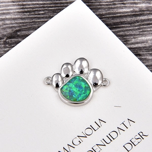 Détail de l'attache bijoux patte de chien avec opale bleue et finition argent sur bois