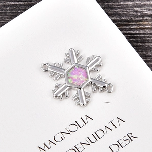 Vista macro del charm a fiocco di neve esagonale con opale rosa e finitura argento