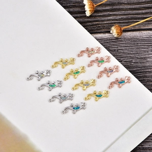 Detail of gecko pendants with colorful opal inlay in silver, gold, and rose gold plating