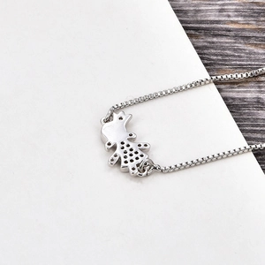 Detailweergave van zilveren boxketting met meisje hanger en holle details aan de kant