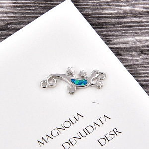 Detailed macro view of silver plated lizard charm with vibrant opal inlay for bracelets