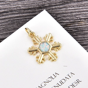 Close-up of golden snowflake pendant with hexagonal light blue opal stone inlay