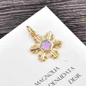 Detailed macro view of a gold snowflake pendant featuring a purple hexagonal opal stone