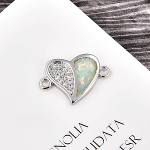 Macro detail of heart-shaped opal connector with micro-paved cubic zirconia for DIY jewelry
