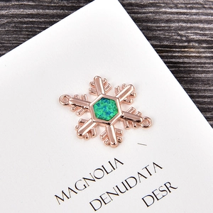 Dettaglio macro del ciondolo a fiocco di neve con opale verde e finitura oro rosa