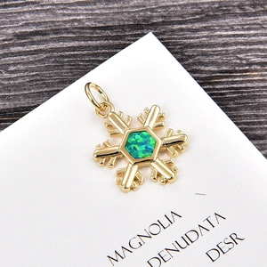Macro detail of snowflake pendant with green opal stone and gold plated copper finish