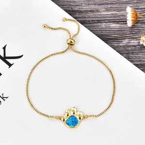 Détail du bracelet réglable en or avec pendentif en opale bleue en forme de patte