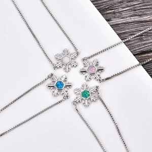 Dettaglio macro della collana con ciondolo a fiocco di neve con opali colorati in argento
