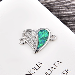 Detailed close-up of a silver heart-shaped opal connector with sparkling white zircon stones