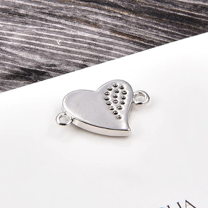 Silver heart-shaped jewelry connector with zirconia accents on white display card