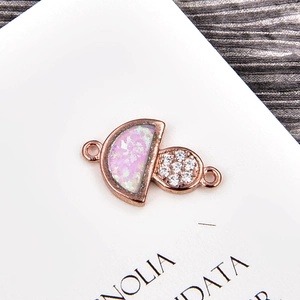 Détail macro d'un pendentif champignon en or rose avec opale rose et zircons fins