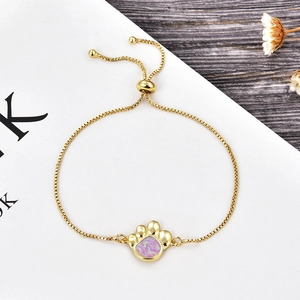 Détail du bracelet ajustable doré avec motif patte en opale rose et zircone cubique