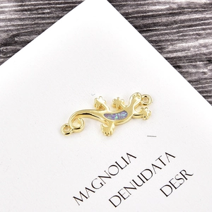 Detailed close-up of gold-plated lizard connector with purple opal inlay for DIY jewelry