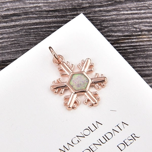 Detailed close-up of rose gold snowflake pendant with hexagonal opal gemstone inlay
