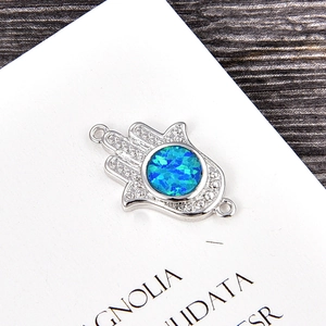 Macro detail of Hamsa Hand connector with blue opal and sparkling zircon accents
