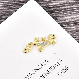Detail of lizard charm with opal inlay and dual gold-plated rings for jewelry making