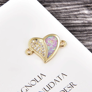 Macro shot of gold heart connector with purple opal and white cubic zirconia accents