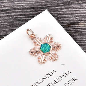 Macro view of snowflake pendant with hexagonal opal in rose gold on a stylish background