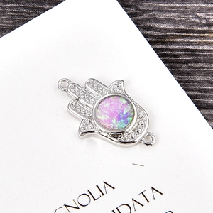 Macro detail of Hamsa hand pendant with white zircon and opal stone for DIY jewelry making