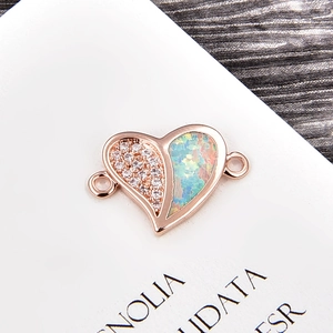 Macro detail of heart charm with white zircon and opal inlay for DIY jewelry