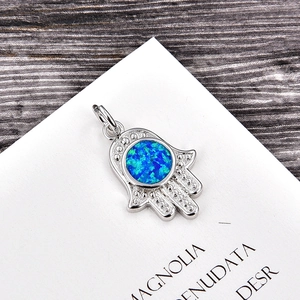 Detailed view of silver Hamsa Hand pendant with a central blue opal stone inlay