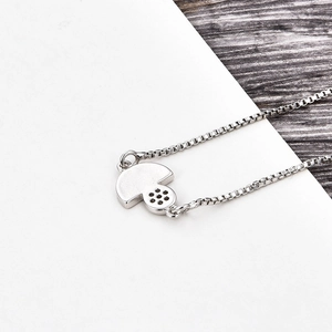Vue détaillée du collier pendentif champignon argenté avec chaîne box sur bois poli