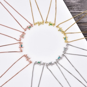 Detailed overhead view of lizard necklaces with opal inlay in gold, rose gold and silver