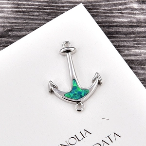 Macro view of anchor-shaped jewelry connector with blue opal inlay and silver plating