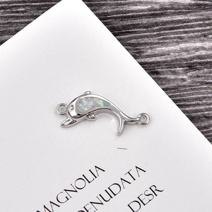Macro shot of dolphin connector with white opal and silver finish for DIY bracelet