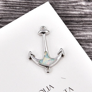 Macro detail of a silver anchor connector featuring a shimmering opal stone inlay