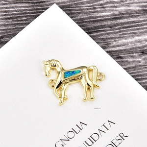 Nahaufnahme eines goldenen Pferdepferdeanhängers mit blauem Opalstein für DIY-Schmuck