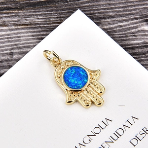 Detailed view of Hamsa Hand pendant with blue opal inlay and gold-plated copper finish