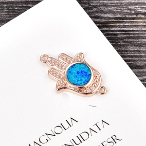 Detail of rose gold Hamsa pendant with blue opal stone and fine microbead edging