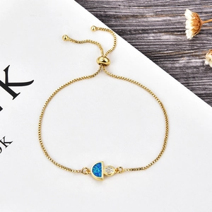 Détail du bracelet ajustable en laiton avec opale bleue et breloques en zircon blanc