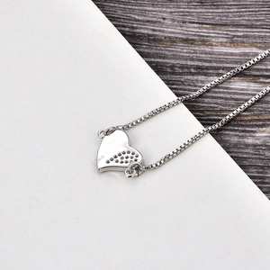 Detail of silver heart pendant showing honeycomb cutout back and sturdy box chain