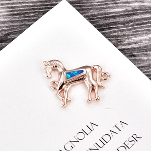 Makroansicht von roségoldenem Pferdeanhänger mit blauem Opal-Inlay für DIY-Schmuck