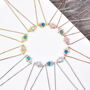 Detailed macro view of Hamsa Hand pendants with colorful opal stones in various metal finishes