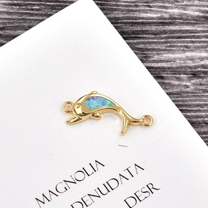 Detailed macro view of a gold dolphin connector with blue opal inlay for jewelry making