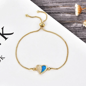 Detail of a heart pendant bracelet with blue opal and sliding clasp on a magazine