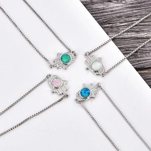 Detailed view of Hamsa Hand bracelets with opal insets and sparkling zircon borders