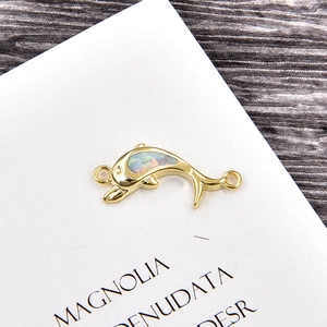 Detail of a gold dolphin jewelry connector with opal inlay for DIY bracelets