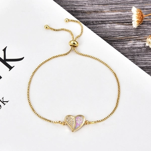 Detail of gold heart bracelet with pink opal and zircon pavé on a classic slider chain