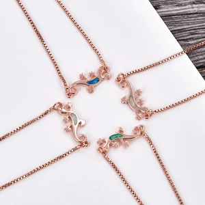Detailed view of rose gold lizard necklaces featuring vibrant inlaid opal stones