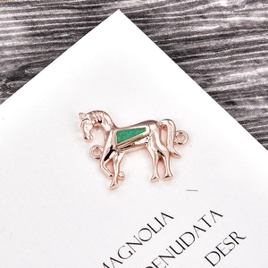 Makroansicht des Roségold-Pferdeanhängers mit grüner Einlage und Doppelringen für DIY-Schmuck