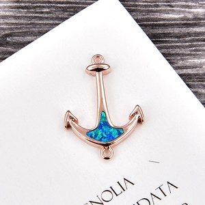 Close-up of anchor jewelry link with rose gold plating and teal opal inlay for DIY design