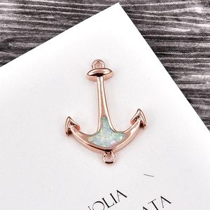 Macro view of rose gold anchor charm with opal stone and cubic zirconia details