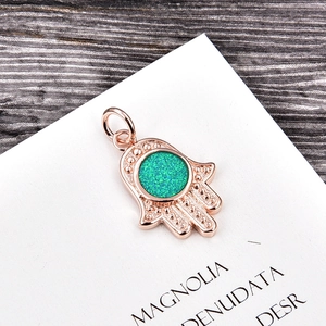 Macro detail of Hamsa Hand pendant in rose gold finish with green opal gemstone