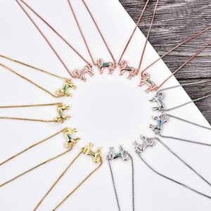 Detaillierte Makroansicht von drei Pferdekopf-Anhängern mit Opal-Inlay in Gold, Rosé und Silber