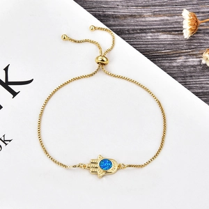 Detail of gold Hamsa Hand bracelet with blue opal stone and adjustable slider clasp